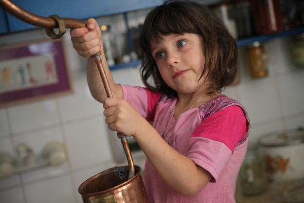 girl helps mom distill rose water